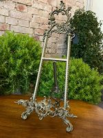 Antique French Rococo style heavy brass tabletop easel featuring ornate scrolling openwork cresting and a deeply detailed asymmetrical rocaille base.