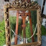 Antique gilt picture frame with bow cresting and historic glass