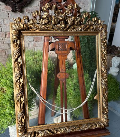 Antique gilt picture frame with bow cresting and historic glass