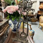 Antique French Art Nouveau cast metal display easel featuring a central cameo medallion of a classical maiden flanked by sculpted lily blossoms.